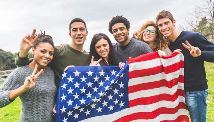 A group of US students holding an American flag. — X/@timeshighereducation