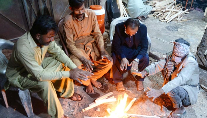 Workers warm their hands by lighting bonfires during a cold wave in Hyderabad.