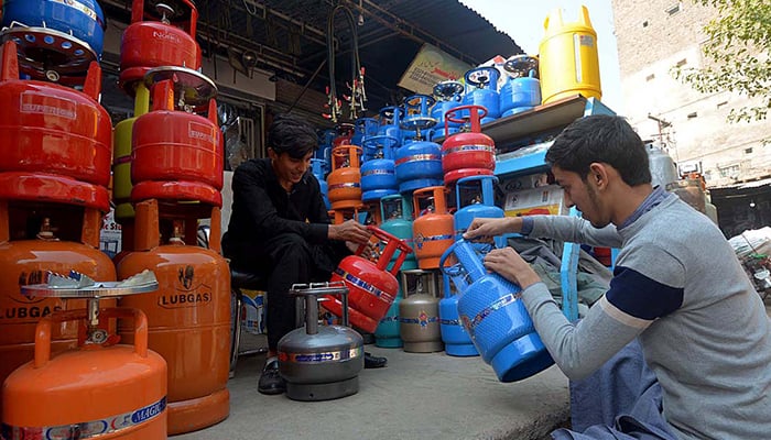 Gas cylinder vendors working at a shop in Peshawar, on November 13, 2023. — APP