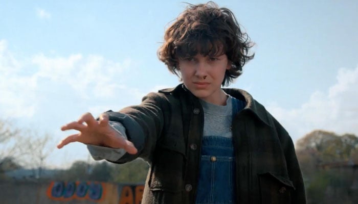 Eleven, a character with telepathic abilities from Stranger Things gestures during a scene. — X/@ign