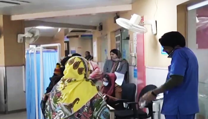 Patients queuing up in front of medical staffers at a Lahore hospital in this undated image in a screengrab taken from a video. — Geo News