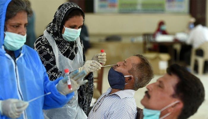 Health official collect swab samples from people to test for the COVID-19 coronavirus in Karachi on September 14, 2020. — AFP
