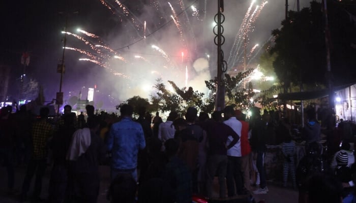 Revellers watch a fireworks show during New Year celebrations in Karachi on early Jan 1, 2023. — AFP