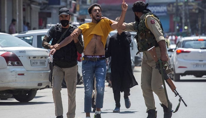 Indian policemen detain a Kashmiri Muslim as devotees defy restrictions for a Muharram procession in Srinagar on August 17, 2021. — AFP