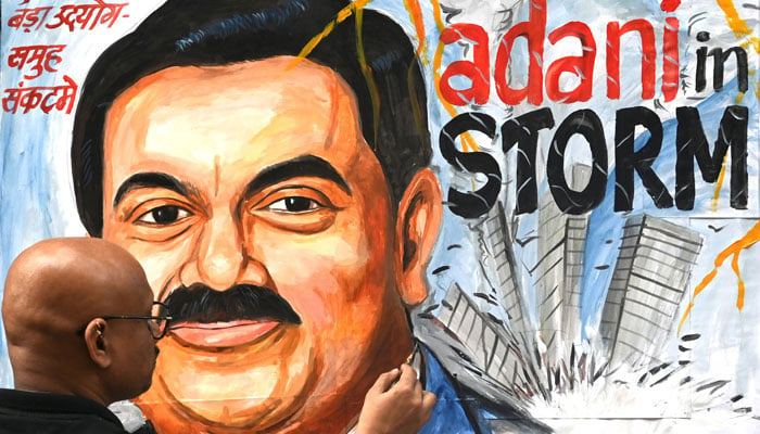 An art school teacher gives final touches to a painting of the Indian businessman Gautam Adani highlighting the ongoing crisis of the Adani group in Mumbai on February 3, 2023. — AFP