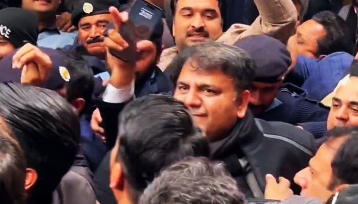 Police personnel escort former federal minister Fawad Chaudhry to present him before a court in Islamabad on January 28, 2023. — X/@PTIofficial