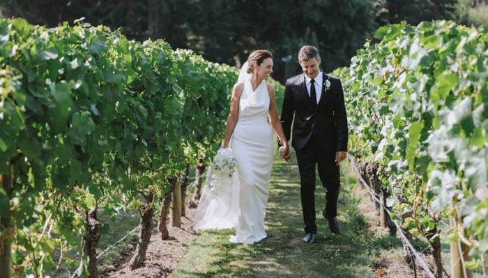 New Zealands former prime minister Jacinda Ardern poses with her husband Clarke Gayford in the Hawkes Bay vineyards on the occasion of her wedding on January 13, 2024. — Stuff via Felicity Jean Photography