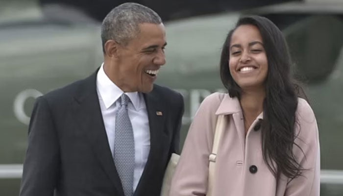 The image shows former US president Barack Obama and Malia Obama smiling. —AFP/file