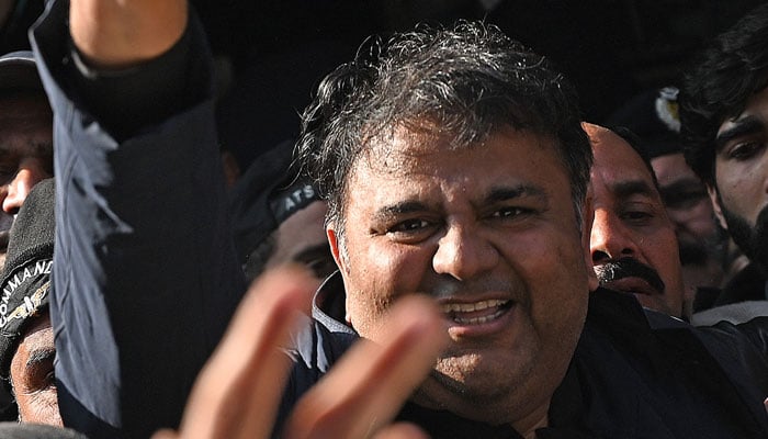 Pakistan´s former information minister Fawad Chaudhry (C) gestures as police officials escort him after a hearing at a court in Islamabad on January 27, 2023. — AFP