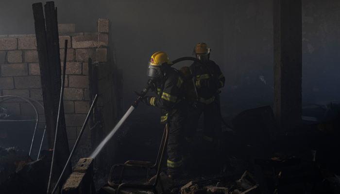 A firefighter extinguishes a fire inside a building in Johannesburg on September 15, 2023. — AFP
