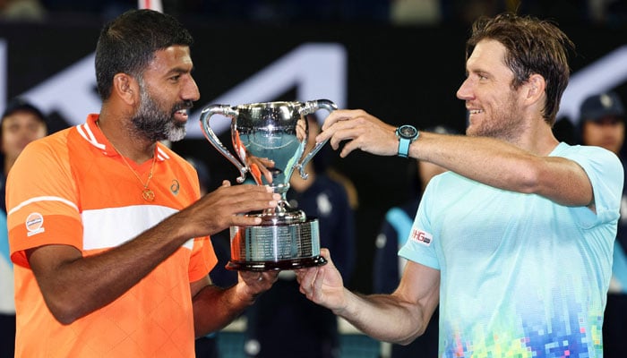 Indias Rohan Bopanna (left) and Australias Matthew Ebden celebrate with the trophy after victory against Italys Simone Bolelli and Andrea Vavassori during their mens doubles final of the Australian Open in Melbourne on January 27, 2024. — AFP