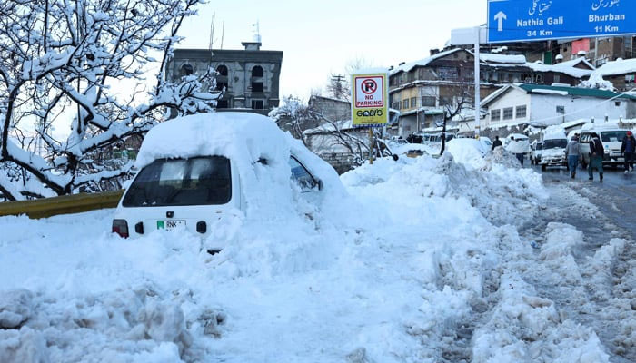 A vehicle is pictured after getting stuck in snow along a road after a heavy snowfall in Murree on January 8, 2022. — AFP