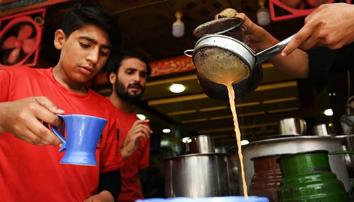 Waiters prepare to serve tea to customers at a restaurant in Islamabad, on June 15, 2022. — AFP