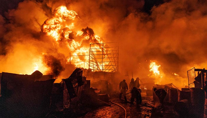 Firemen and bystanders extinguish a fire in the Makadara area of Nairobi on January 30, 2024. — AFP