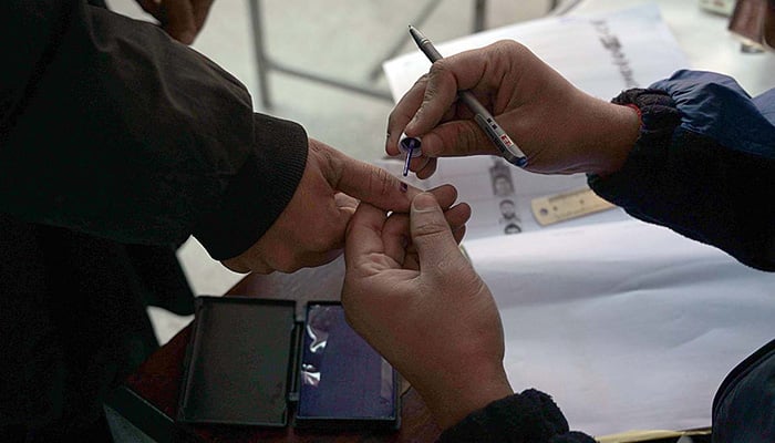Polling officer mark the thumb of voter before issuing ballot paper in Rawalpindi during general elections on February 8, 2024. — APP