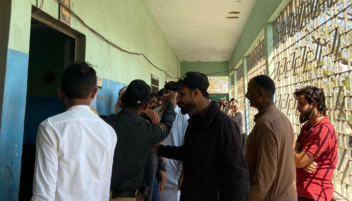 Voters queue up at a polling station in Karachi on February 8, 2024. — The News