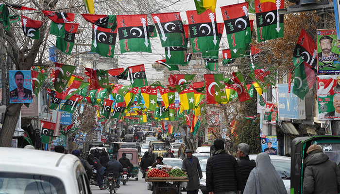 This photo taken on February 3, 2024, shows a street adorned with flags of political parties ahead of Pakistans national elections, in Quetta. — AFP
