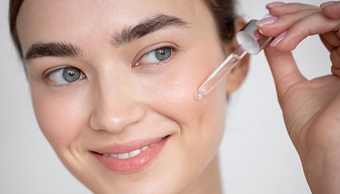 Representational image of a woman applying serum on her face. — Glam Up Girls/File