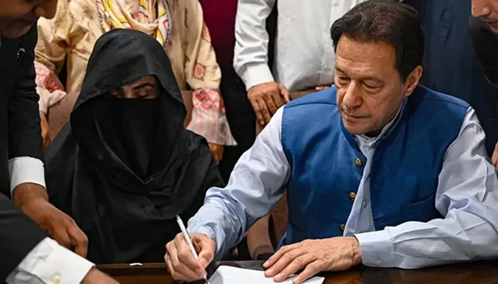 PTI Chairman Imran Khan (right) and his wife Bushra Bibi. — AFP/File