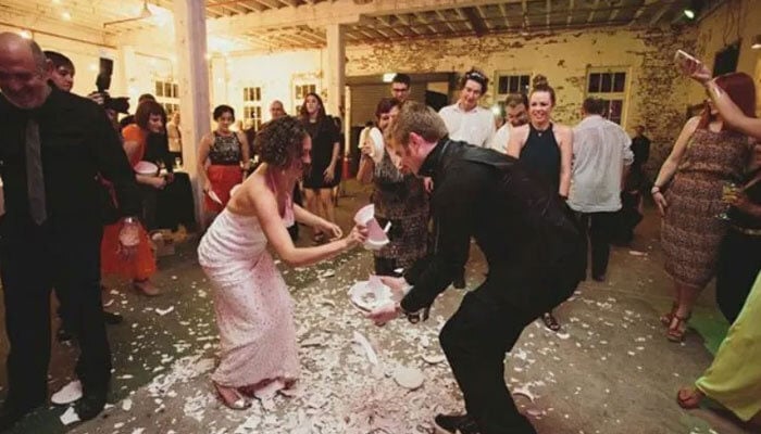 The image shows guests smashing plates at a party. — Wander On/File