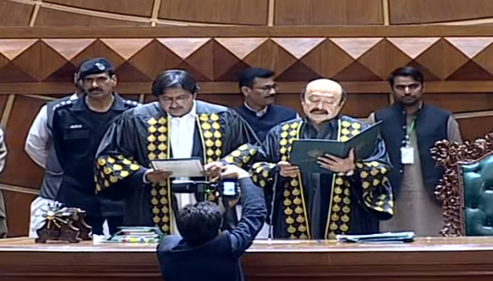 Outgoing Punjab Assembly Speaker Sibtain Khan administer's oath to his successor Malik Ahmed Khan (left). — Geo News