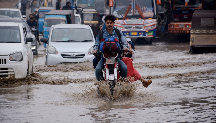 Vehicles are passing through rainwater accumulated on the Korangi road after heavy rain in Karachi on February 4, 2024. —APP