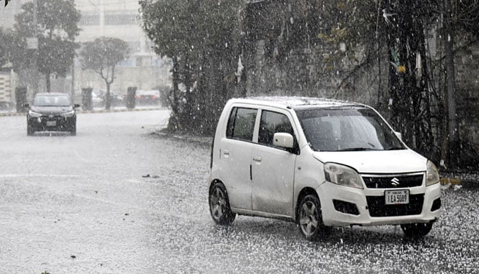 Motorists on their way at a road during heavy rain and hailstones in Islamabad on March 2, 2024. — Online