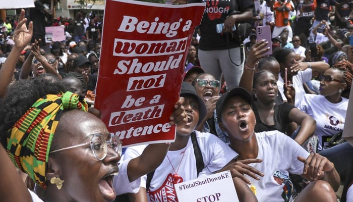 Activists hold up placards as they march through the Central Business District at a demonstration against an alarming rise in murders of young women in Nairobi on January 27, 2024. — AFP