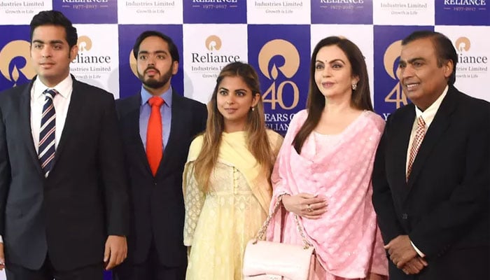 Mukesh Ambani and Nita Ambani pose with their children Akash Ambani, Anant Ambani, and Isha Ambani as they arrive for Reliance Industries 40th AGM in Mumbai on July 21, 2017. — AFP