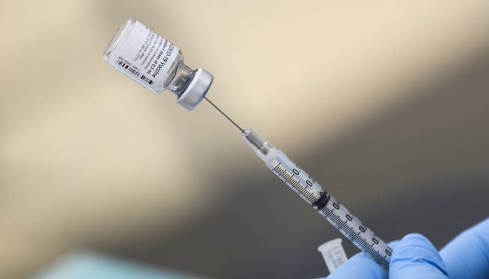 A syringe is filled with the first dose of the Pfizer Covid-19 vaccine, taken on August 16, 2021. — AFP