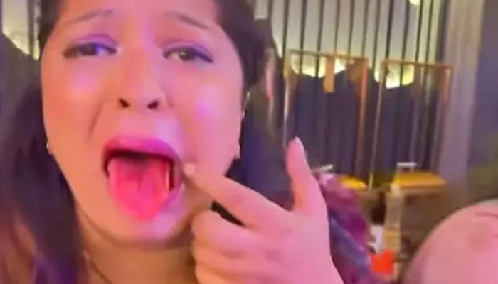 Woman showing her moth to the camera after dry ice caused her to spit blood at a Gurugram restaurant. — TikTok video