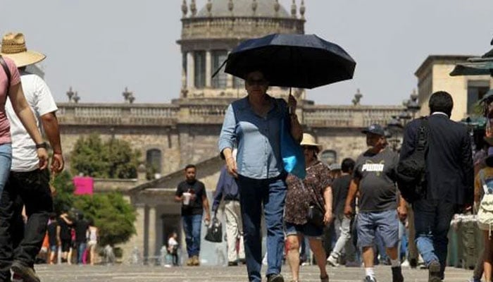 This representational picture shows tourists and locals walking in scorching heat in Mexico on June 12, 2023. — AFP