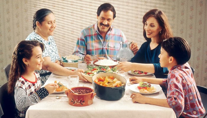 A representational image of a family happily eating food. — Unsplash