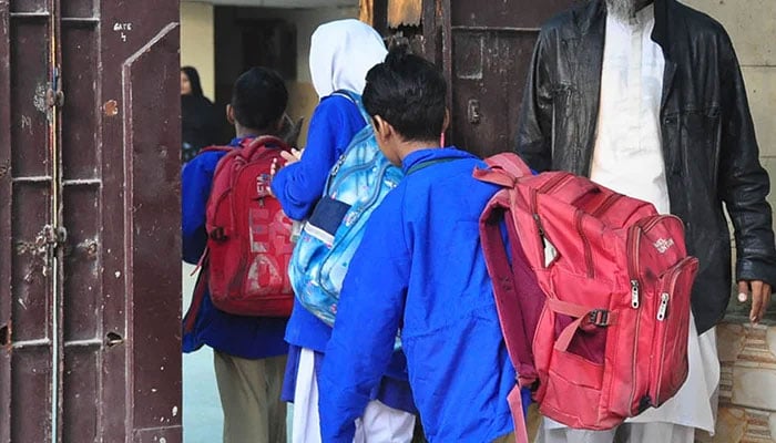Students arrive at their school on their first day after the end of winter break in Karachi, on January 1, 2024. — Online