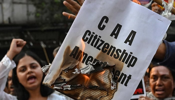 Activists shout slogans as they burn a copy of the Citizenship Amendment Act (CAA) bill during a protest rally in Kolkata on March 12, 2024. — AFP/File