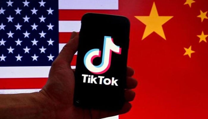 Logo for TikTok is displayed on the screen of an iPhone in front of a US flag and Chinese flag background in Washington, DC, on March 16, 2023. — AFP