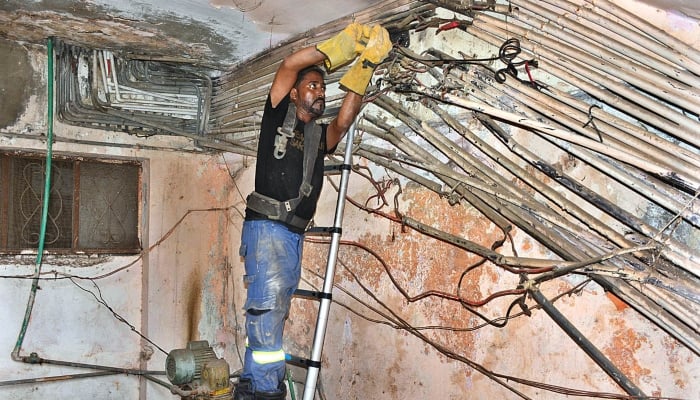 A HESCO lineman is busy in cutting illegal line of electricity during a crackdown against illegal connections in Hyderabad on September 18, 2023. —APP
