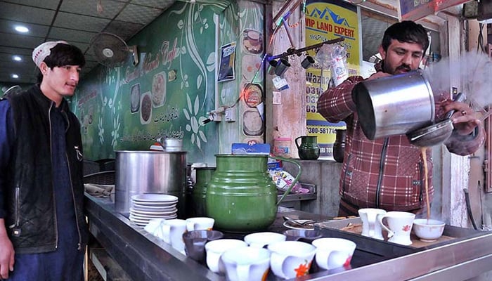A vendor preparing tea for his customers in a local hotel in Islamabad. — APP