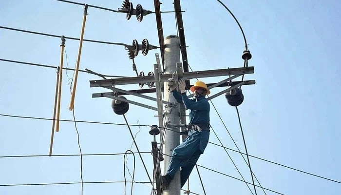 A FESCO worker fixes a line on an electric pole on December 19, 2022. — APP