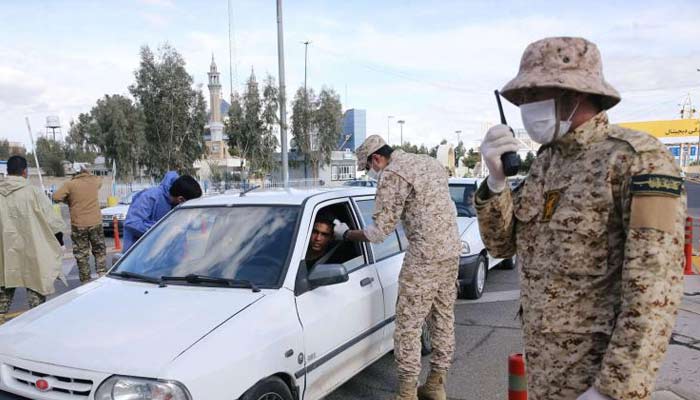 Islamic Revolutionary Guard Corps (IRGC) troops inspect cars at the entrance to Qom, Iran. --AFP/File