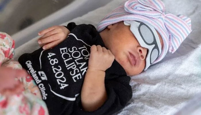 Cleveland Clinic NICU celebrates upcoming total solar eclipse 2024 with tiny patients. (Baby Ella wears a total solar eclipse onesie, courtesy of the Cleveland Clinic. — Cleveland Clinic)