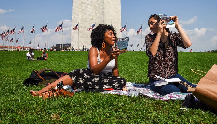 Washington natives Autumn Spears (left) and Alice Kostovisky watch the solar eclipse on August 21, 2017 in Washington, DC.  - 