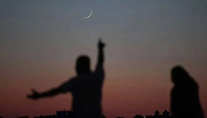 A man reacts to seeing the crescent moon in the sky. --AFP/File