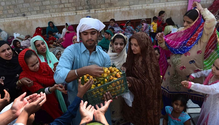 A man distributes fruits to pilgrims. during the Baisakhi festival celebrations. — AFP/File