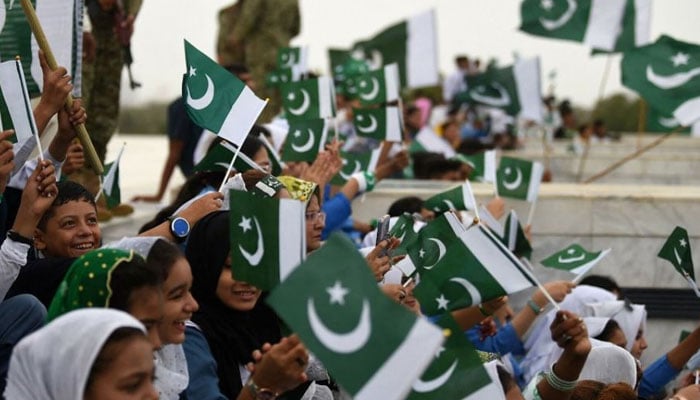 Students wave national flags at the mausoleum Quaid-i-Azam Mohammad Ali Jinnah during Independence Day celebrations in Karachi on August 14, 2023. — AFP