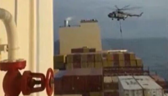 Irans Revolutionary Guards seen rappelling down onto MSC Aries container ship near the Strait of Hormuz. —AFP