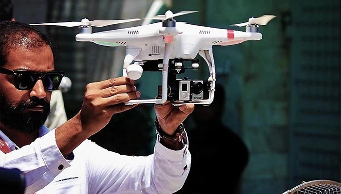 An operator holds a drone camera before a lift-off in this undated picture. — AFP/File