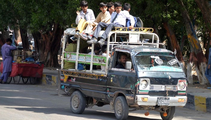 Students are seen commuting on an overloaded van in Hyderabad on April 23, 2024. — INP