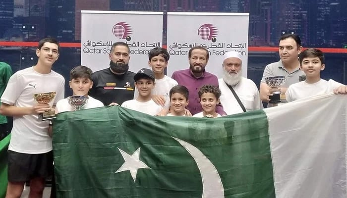 Pakistani squash players and officials holding national flag during Qatar Junior Squash Championship in Doha in this undated photo. — Facebook/@KPSquashAssociation