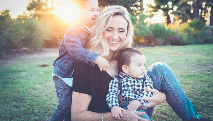 Representational image of a woman with her two kids. — Unsplash